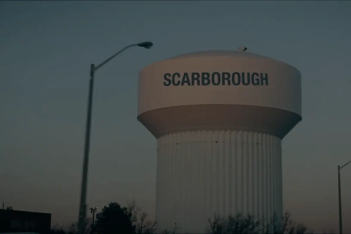The Scarborough water tower at first light above low rooftops.